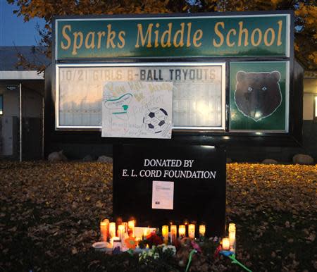 Lighted candles flicker in the pre-dawn light at Sparks Middle School following Monday's shooting in Sparks, Nevada, October 22, 2013. REUTERS/Marilyn Newton/Reno Gazette-Journal