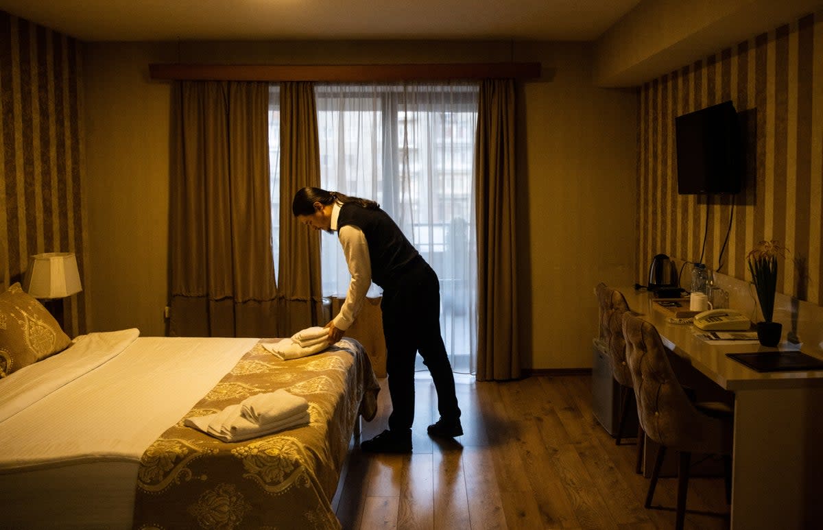 Antropov checks a room before guests arrive at Pino Vere Palace Hotel where he works (Reuters)