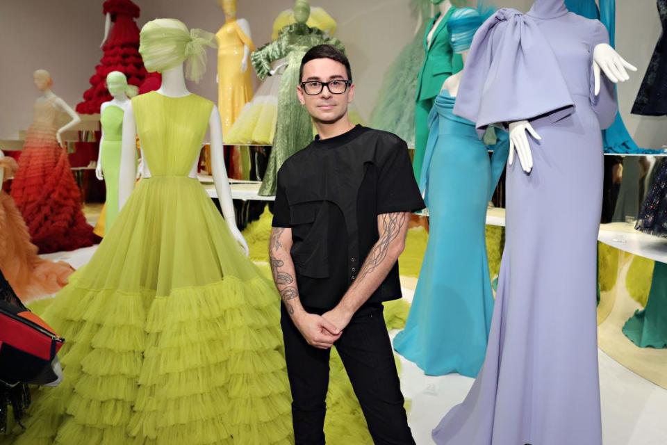 Christian Siriano with his colorful gowns in the background