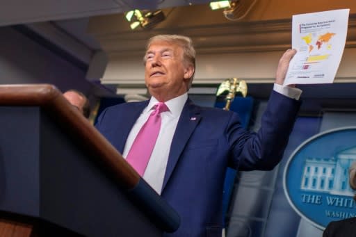 US President Donald Trump holds up a document showing "countries best and worst prepared for an epidemic" during a news conference on the COVID-19 outbreak at the White House on February 26, 2020