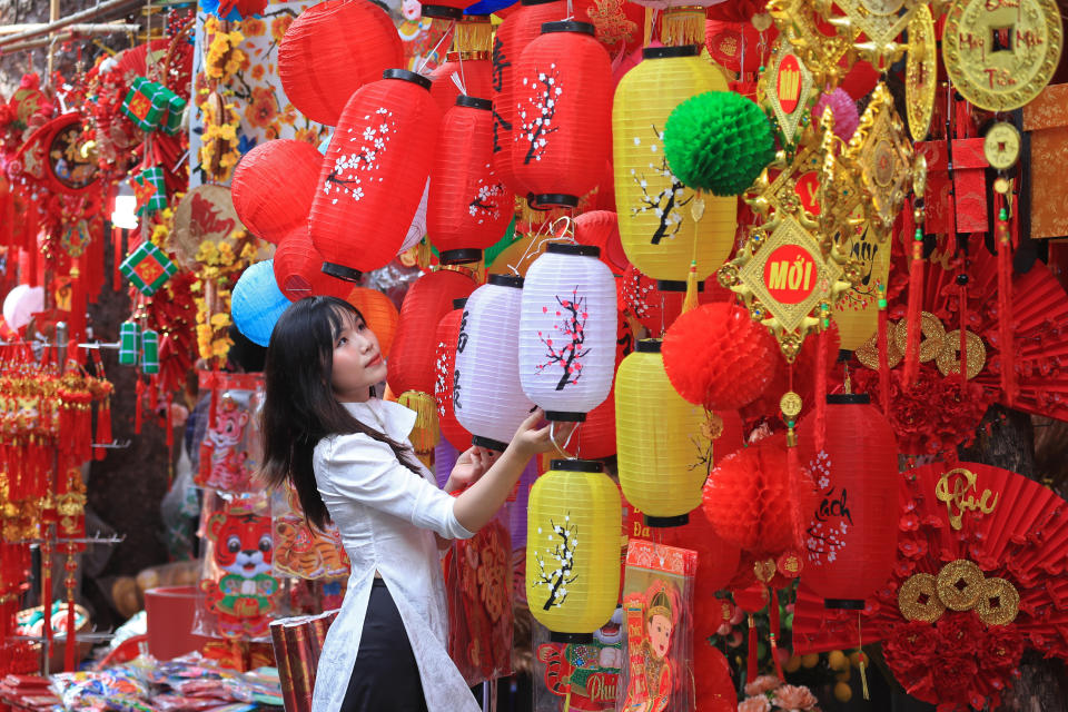 A woman looks at lanterns at the traditional Lunar New Year "Tet" market in the old quarter of Hanoi, Vietnam, Friday, Jan. 28, 2022. (AP Photo/Hau Dinh)