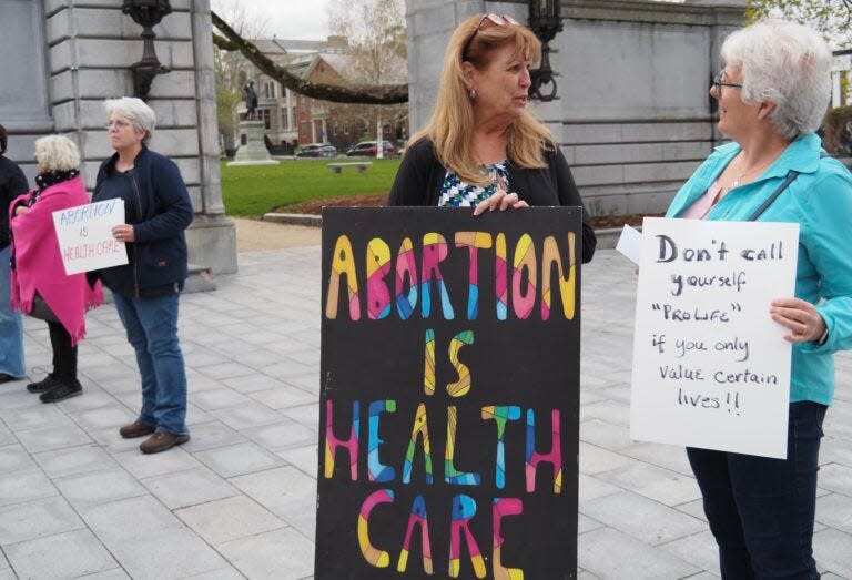 Dalia Vidunas (center), executive director of the Equality Health Center in Concord, and Lisa Spring of Pembroke attend an abortion rights rally at the State House Tuesday.