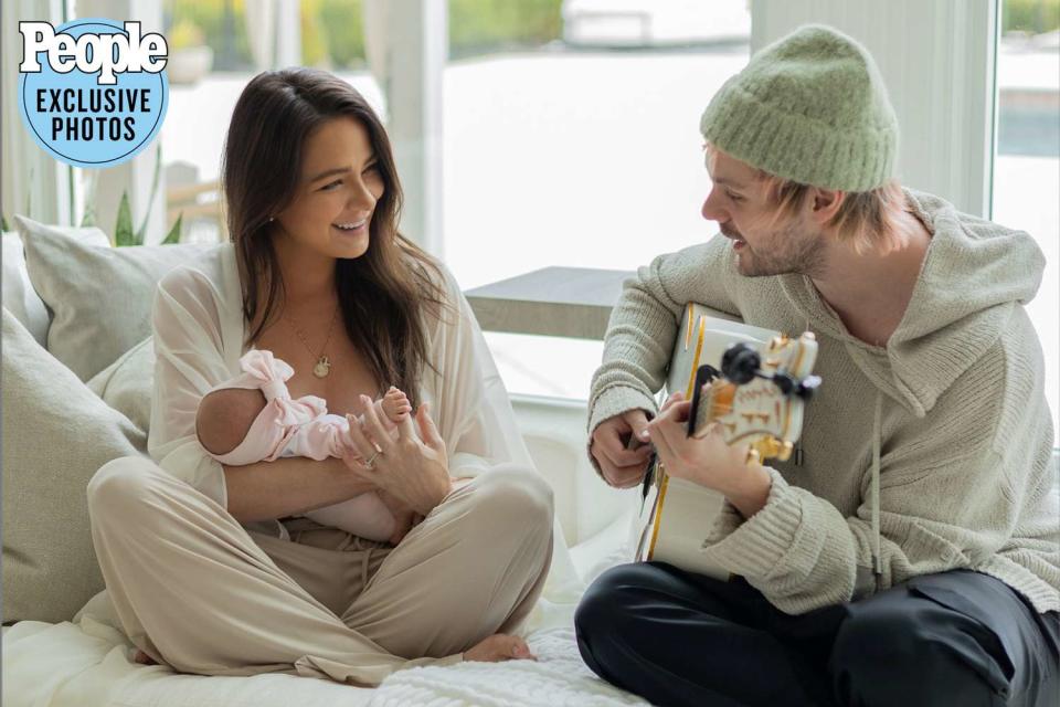 <p>Hannah Cree Photography</p> Michael Clifford playing guitar for wife Crystal and baby Lua