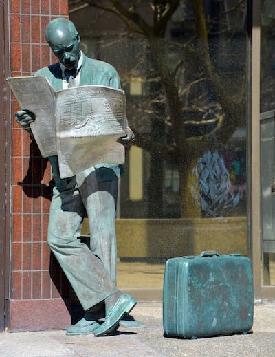 A statue in Westmount, Que. of a man reading the ‘Montreal Gazette.’ (Shutterstock)