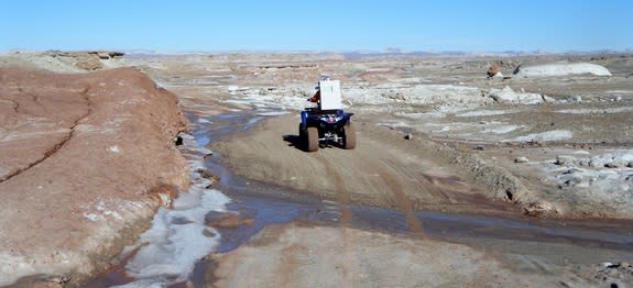 Journalist Elizabeth Howell riding an all-terrain vehicle in a spacesuit near Utah's Mars Desert Research Station, Jan. 15, 2014.