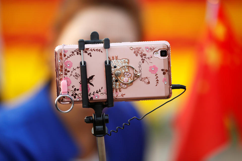 <p>A woman takes pictures of herself as people gather in Tiananmen Square to celebrate National Day marking the 67th anniversary of the founding of the People’s Republic of China, in Beijing October 1, 2016. (REUTERS/Damir Sagolj) </p>