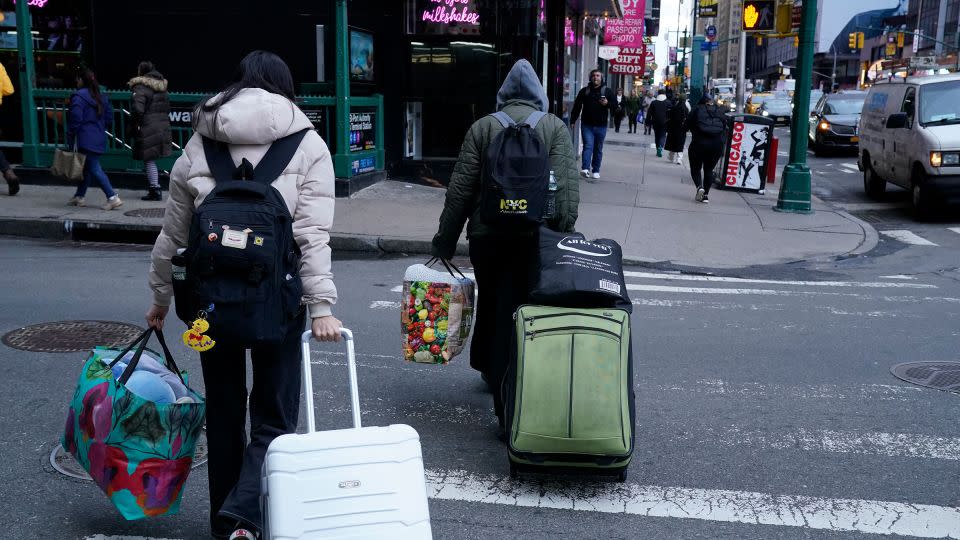 A migrant family leaves the Row Hotel in midtown Manhattan January 10, 2024. - Timothy A. Clary/AFP/Getty Images