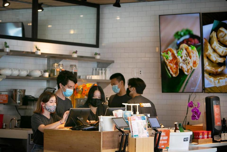 Mary Catherine Lorié, 19, works the cash register as fellow teen employees Dave Buitrago, 18; Samantha Su, 19; Kyle Ng, 16; and Michael Concordia, 19, work beside her at the Sushi Maki in Dadeland.