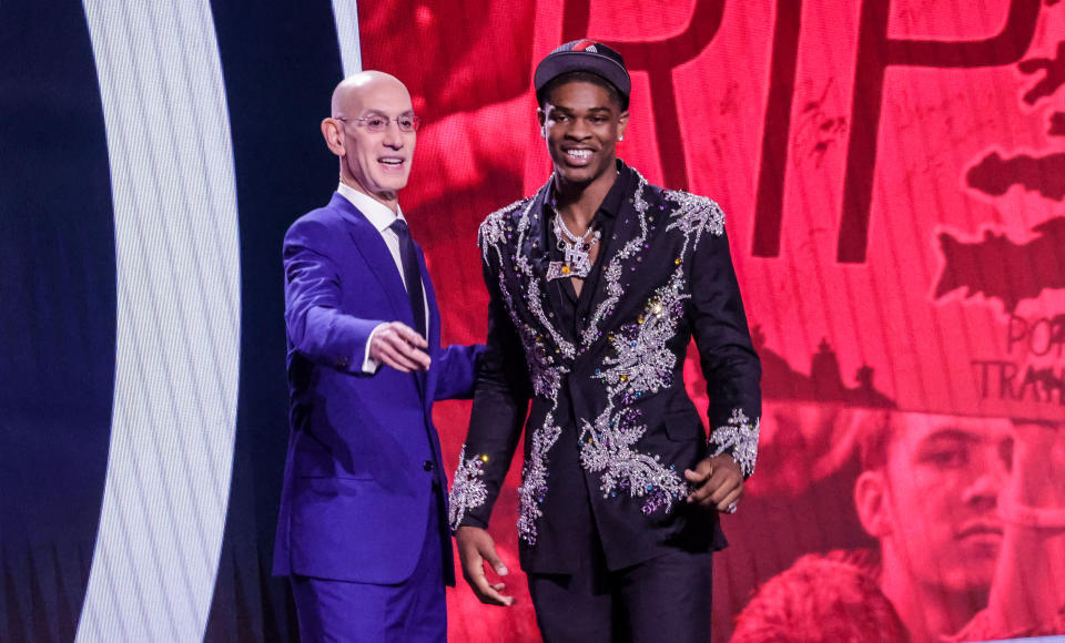 NBA commissioner Brandon Miller (L) shakes hands with Scoot Henderson (R) 