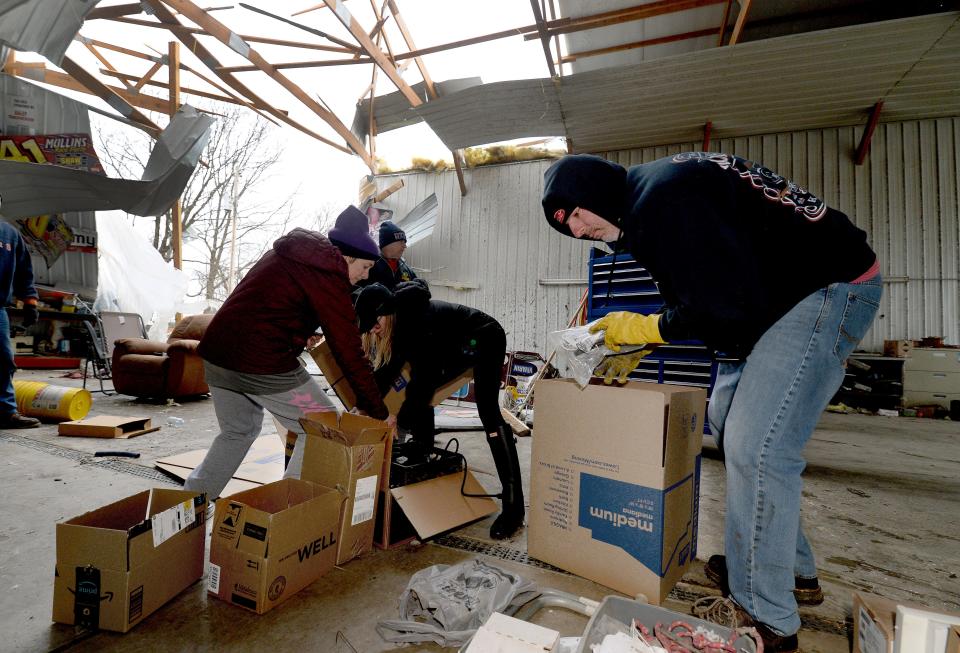A friend Flea Ruzic of Springfield, right, helps gather up anything that can be saved Saturday, April 1, 2023, from the tornado-damaged business Ealey Transportation Inc. that belongs to Jack Ealey and Brenda Brooks in Sherman.
