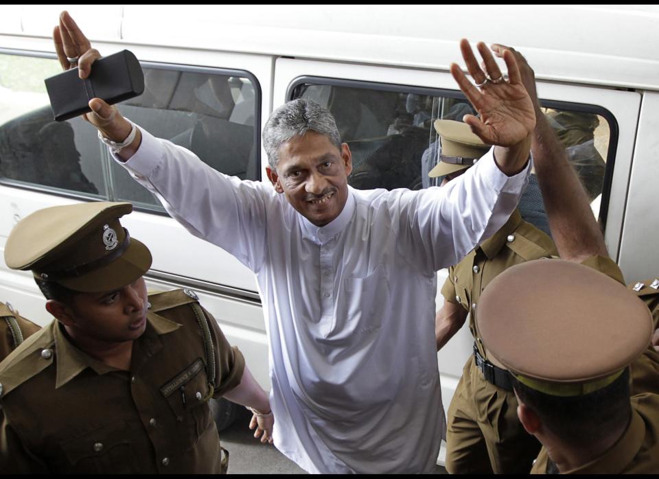 FILE - In this Dec. 16, 2011 file photo, defeated presidential candidate and former army chief Sarath Fonseka gestures as he is escorted by prison guards to a court room in Colombo, Sri Lanka. High Court granted bail for Fonseka on Friday, May 18, 2012, a move seen as a step toward a full pardon for the man credited with ending the country's long civil war but who later was jailed after challenging the president in elections. (AP Photo/Gemunu Amarasinghe, File)