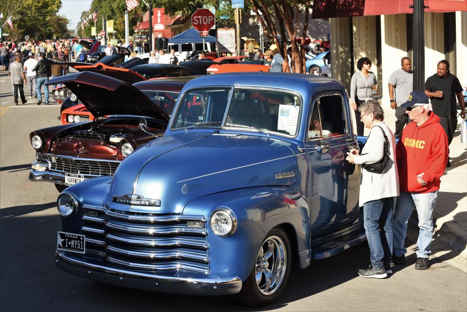 Attendees to the 15th annual Heroes & Hotrods Veterans Weekend Car Show in Bastrop admire a 1951 Chevrolet pickup.