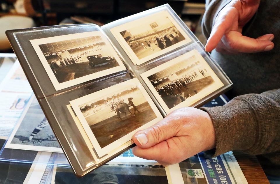 John Mack of Copley Circle Antiques shows undated photographs from a parade at the old Cleveland Municipal Stadium.