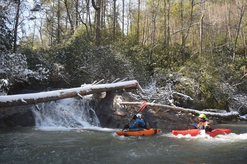 Two kayakers run through Ellicott Rock on the Chattooga River. Feb. 9, 2020.