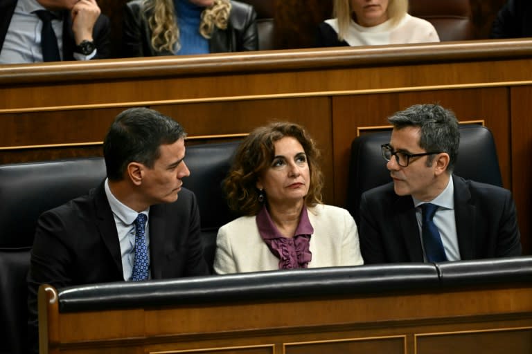 El presidente Pedro Sánchez (izq) habla con el ministro Félix Bolaños con la vicepresidenta María Jesús Montero en medio, durante una sesión del Congreso de los Diputados español, el 30 de enero de 2024 en Madrid (Javier Soriano)
