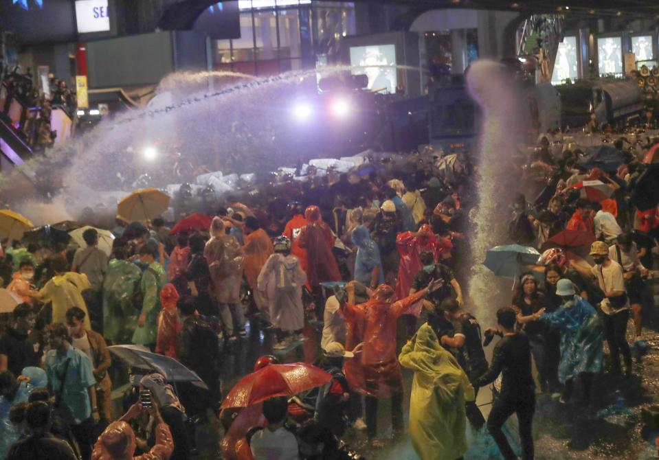 Police fire water cannons to disperse pro-democracy demonstrators gathering in an intersection of a business district in Bangkok, Thailand, Friday, Oct. 16, 2020. Thailand's prime minister has rejected calls for his resignation, while his government failed to stop student-led protesters from rallying in the capital for a second day in defiance of a strict state of emergency. (AP Photo/Sakchai Lalit)