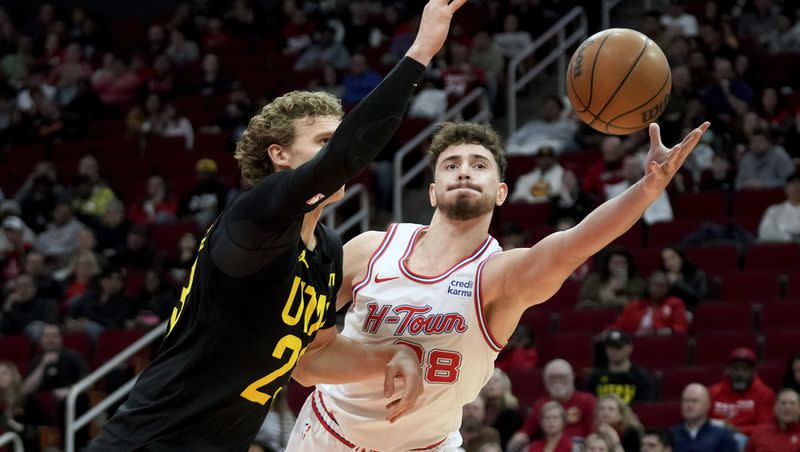 Houston Rockets center Alperen Sengun, right, and Utah Jazz forward Lauri Markkanen reach for a loose ball during the first half of an NBA basketball game Saturday, Jan. 20, 2024, in Houston. (AP Photo/Eric Christian Smith)