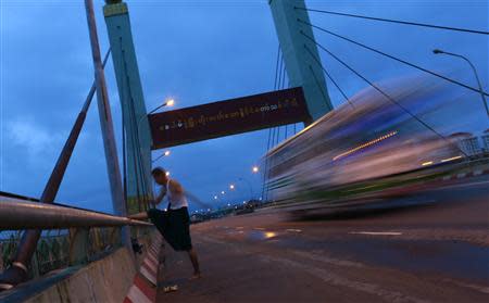 A man stretches early in the morning on the Banduhla bridge, in Yangon, September 6, 2013. REUTERS/Soe Zeya Tun