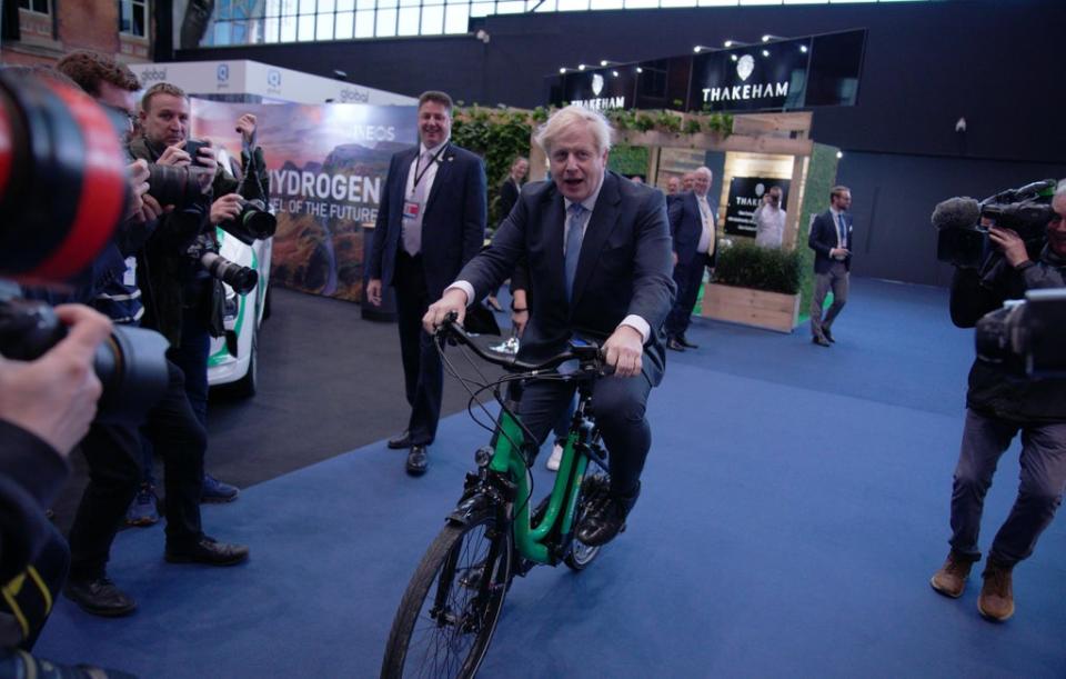 A rare moment of levity in 2021 for Mr Johnson as he rides a bicycle in the Manchester Central Convention Complex during the Conservative Party Conference (Peter Byrne/PA) (PA Wire)