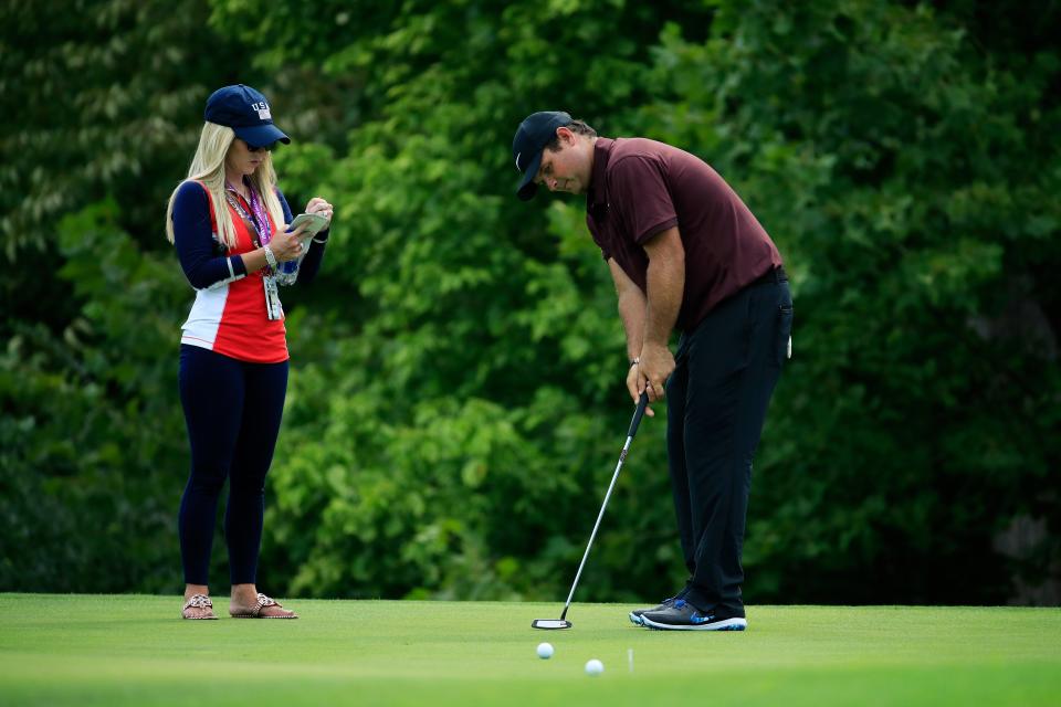 ST. LOUIS, MO - AUGUST 06:  Patrick Reed of the United States putts as wife Justine Karain looks on during a practice round prior to the 2018 PGA Championship at Bellerive Country Club on August 6, 2018 in St. Louis, Missouri.  (Photo by Andy Lyons/Getty Images)