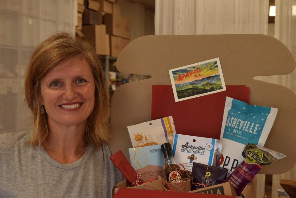 Amy Jones, an employee at Asheville Goods, stands next to an Asheville Goods gift box.