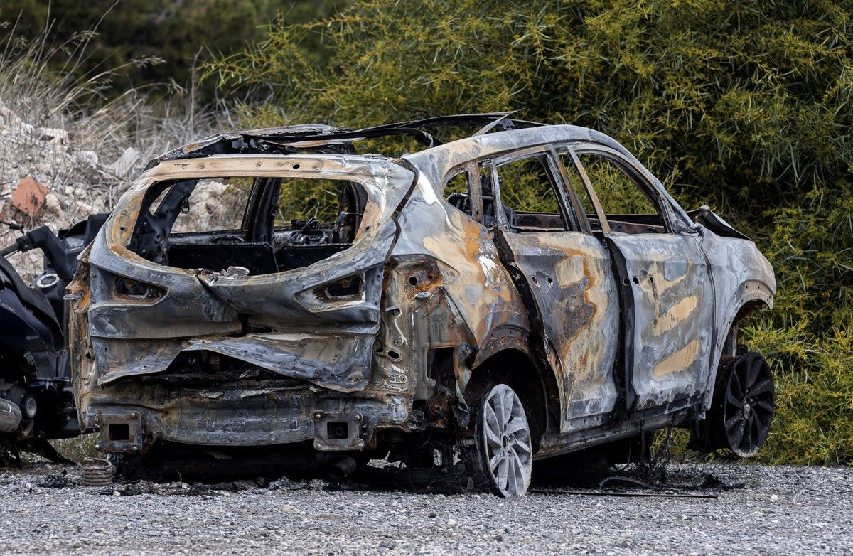 A burned car allegedly used by the killers to escape the scene is parked outside the Guardia Civil barracks, in El Campello (Reuters)