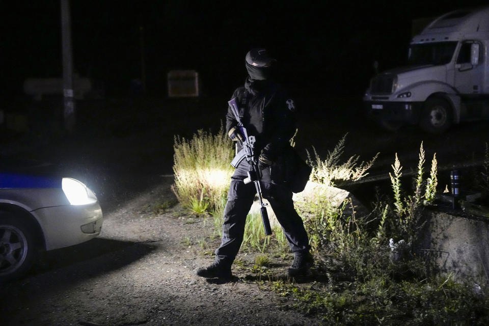 A Russian serviceman guards a road near a private jet crash, near the village of Kuzhenkino, Tver region, Russia, early Thursday, Aug. 24, 2023. Officials say a private jet has crashed over Russia, killing all 10 people on board. Mercenary chief Yevgeny Prigozhin was on the passenger list, and Russia's civil aviation agency says he was on board. (AP Photo/Alexander Zemlianichenko)