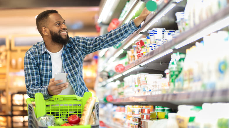 man shopping in dairy aisle