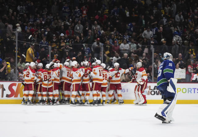 Vancouver Canucks goalie Thatcher Demko (35) skates off the ice as the Calgary Flames celebrate Tyler Toffoli's overtime goal in an NHL hockey game Friday, March 31, 2023, in Vancouver, British Columbia. (Darryl Dyck/The Canadian Press via AP)