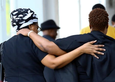 Visitors embrace as they leave Singapore Casket, the funeral parlour where the body of the late former Zimbabwe's President Robert Mugabe is being held in Singapore