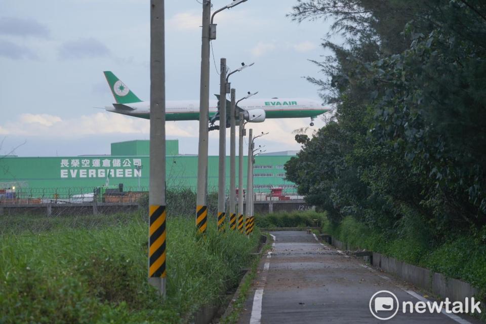 長榮航空一架飛機準備降落桃園機場，前方已經荒廢的農地即為第三跑道預定地。   圖：張良一/攝