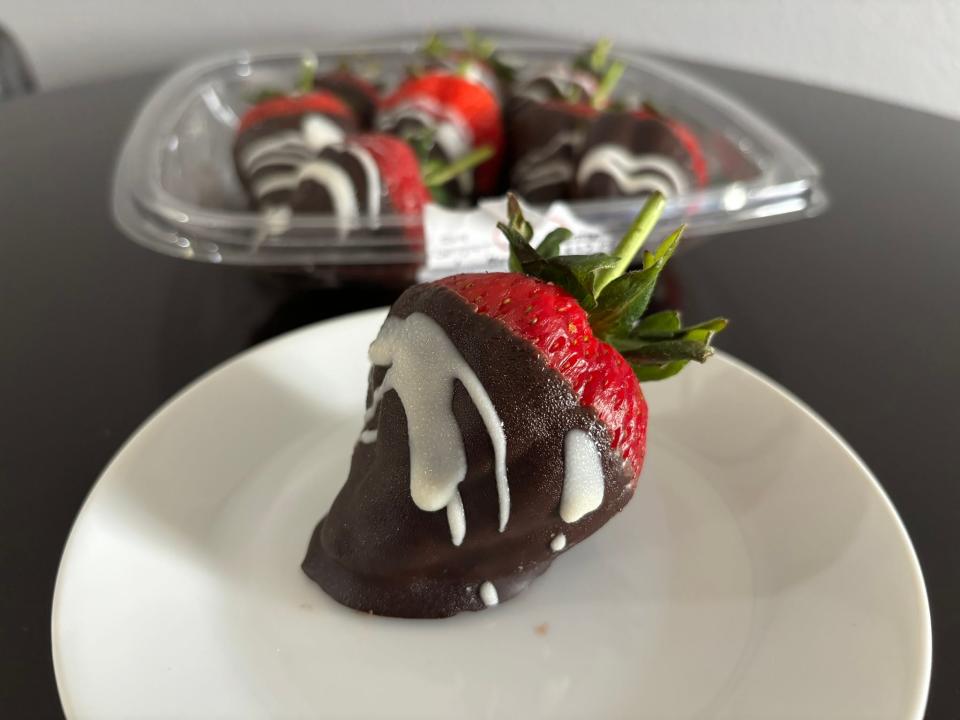 Single chocolate-covered strawberry on plate 