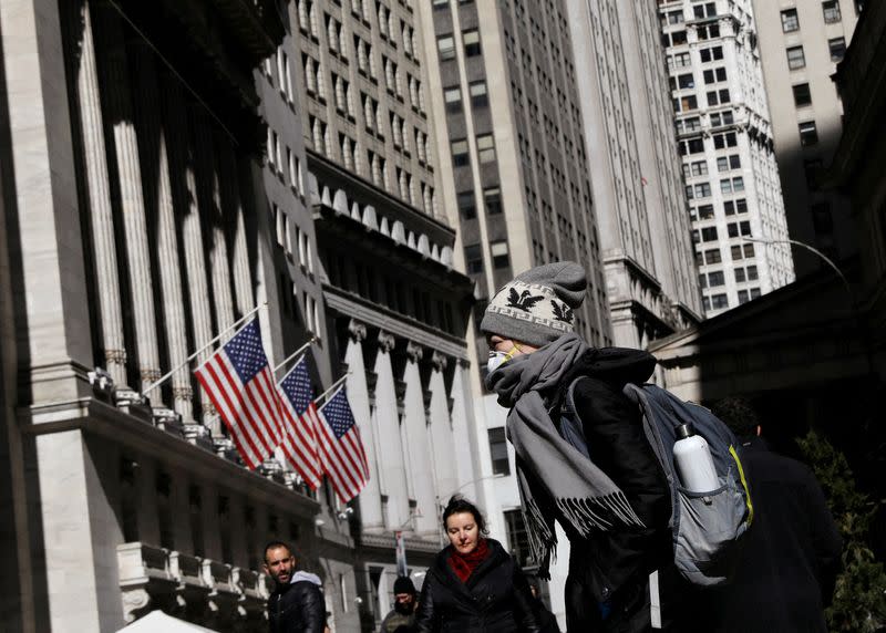 FILE PHOTO: A woman wears a mask near the NYSE in the Financial District in New York