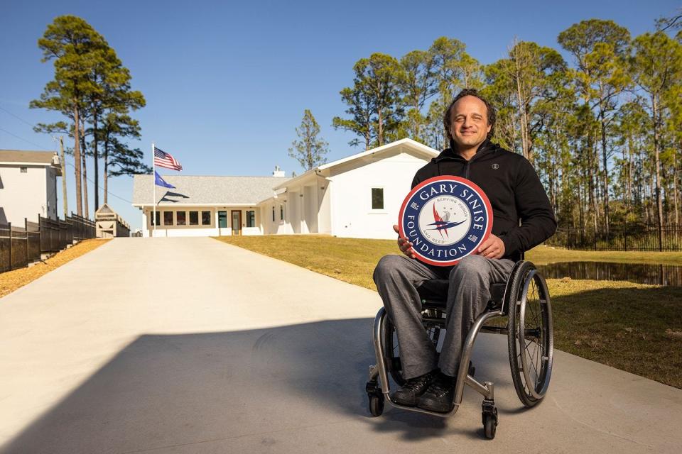 Retired Air Force Staff Sgt. Brian Schiefer poses in front of the Santa Rosa Beach home built for him mortgage-free through the R.I.S.E. program of the Gary Sinise Foundation.