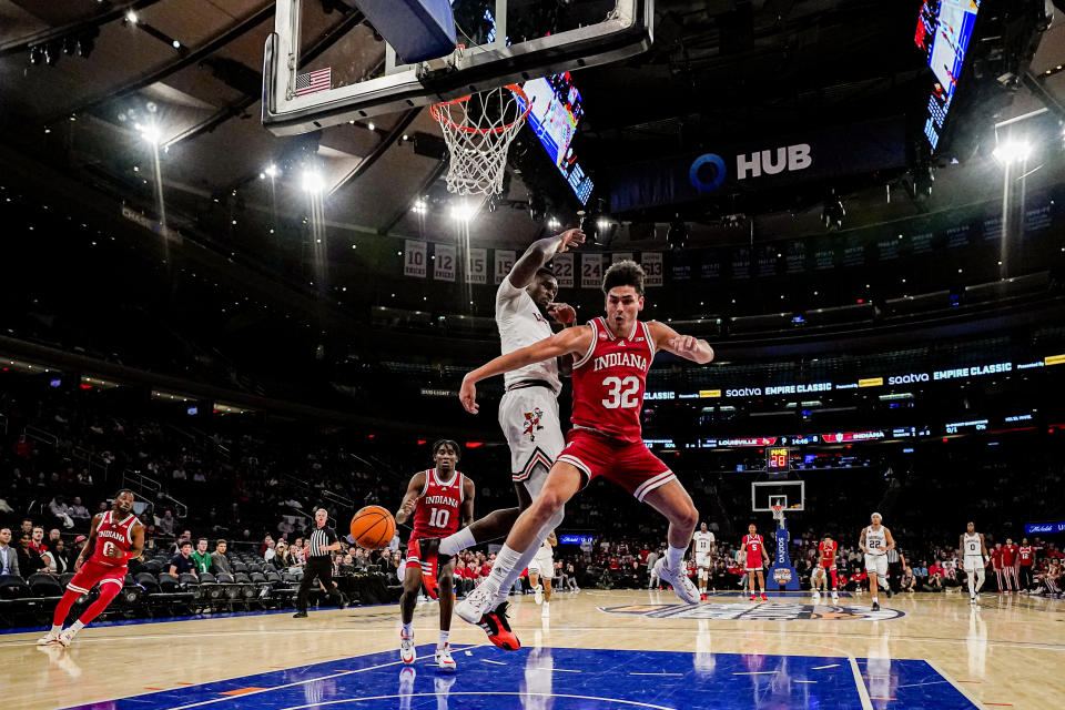 Indiana guard Trey Galloway (32) attempts a no-look pass to teammate Indiana forward Kaleb Banks in an NCAA college basketball game against Louisville in the Empire Classic tournament in New York, Monday, Nov. 20, 2023. (AP Photo/Peter K. Afriyie)