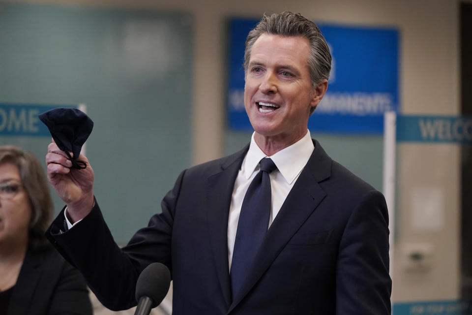 FILE — In this July 26, 2021 file photo Gov. Gavin Newsom holds a face mask while speaking at a news conference in Oakland, Calif. Conservative radio talk show host Larry Elder has emerged as the top contender for those who are looking to unseat Newsom in the Sept. 14th recall election. Elder, who is running to replace Newsom in the Sept. 14 recall election, says he would erase state vaccine and mask mandates, is critical of gun control, opposes the minimum wage and disputes the notion of systemic racism in America. (AP Photo/Jeff Chiu, File )