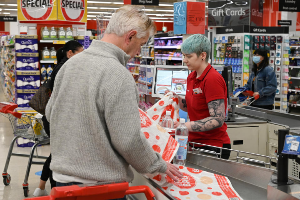 Coles cashier ringing up groceries