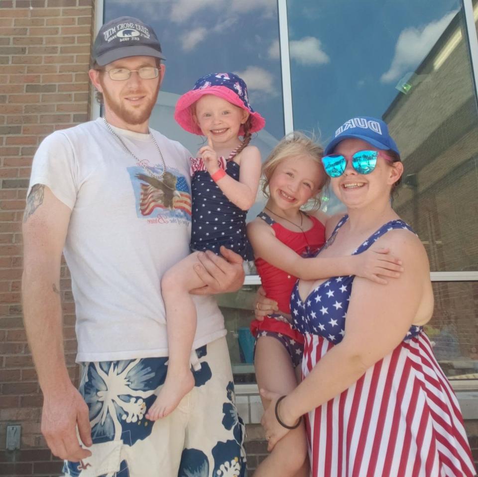 Taylor Hughett, right, holds daughter Clairissa while her sweetheart, Casey Weekley, holds their other daughter, Charlotte, at the YMCA for family pool time on the Memorial Day holiday