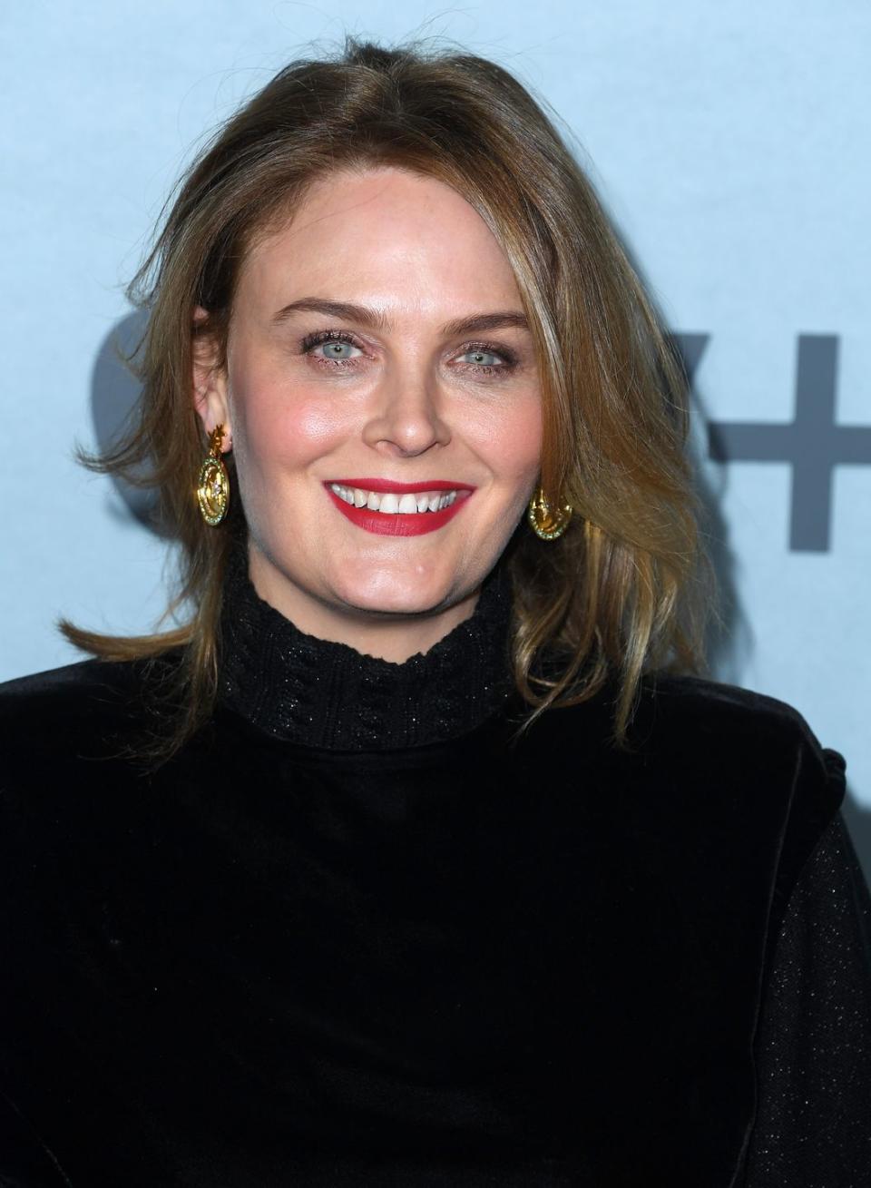 emily deschanel in a black dress with big gold earrings at an apple tv event