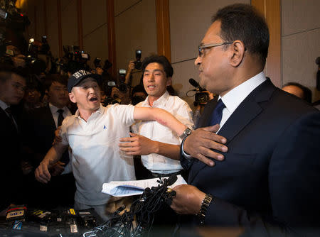 Family member of victims who have injuries linked to the use of humidifier sterilizers, some marketed by Reckitt Benckiser, complains to Ata Safdar (R), head of Reckitt Benckiser Korea and Japan, during his news conference to apologize for deadly lung injuries linked to the use of the humidifier sterilizers in Seoul, South Korea, May 2, 2016. Yonhap/Yun Dong-Jin/via Reuters