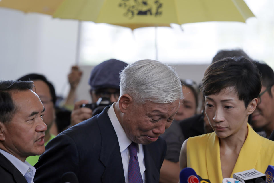 Occupy Central leader Chu Yiu-ming, center, cries as he speaks to media after sentencing at a court in Hong Kong, Wednesday, April 24, 2019. A court in Hong Kong handed down prison sentences of up to 16 months Wednesday to eight leaders of massive 2014 pro-democracy protests on charges of public nuisance offenses. (AP Photo/Kin Cheung)