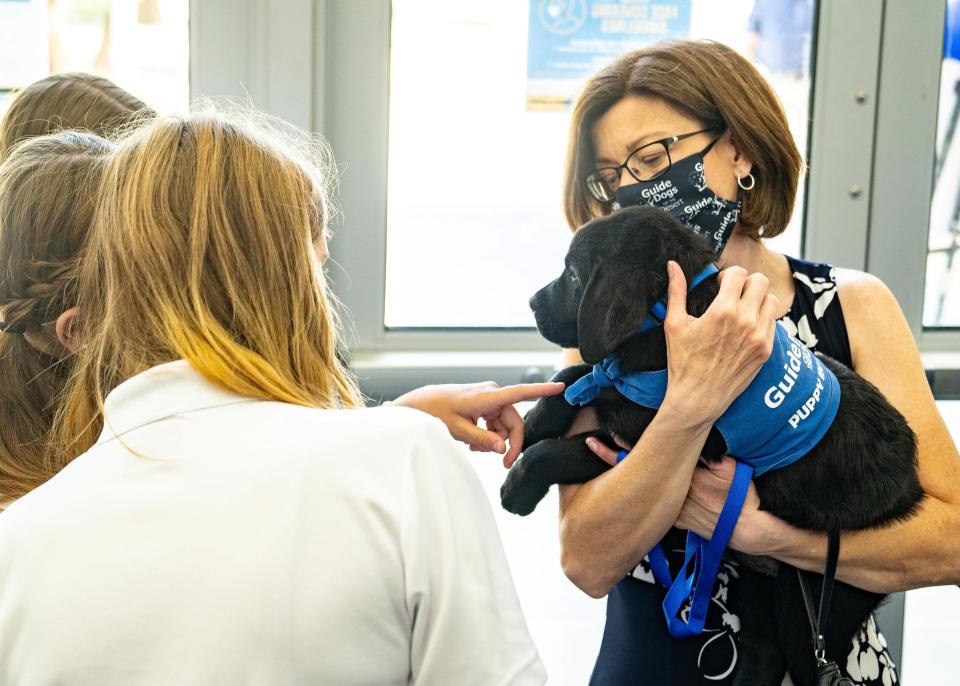 Tricia Gehrlein, Guide Dogs board secretary shows off black labrador puppy North at the Guide Dogs of the Desert graduation ceremony on May 21, 2022.