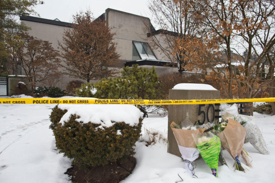 flowers left outside of the house that has police tape around it