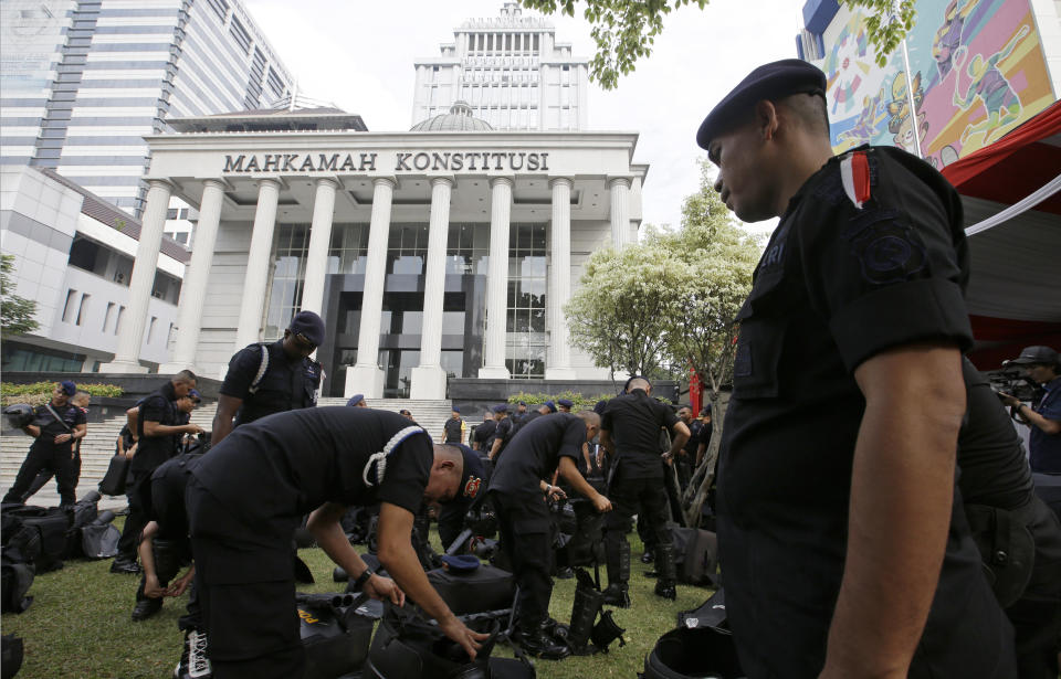 Indonesian police officers are deployed outside the Constitutional Court in Jakarta,Indonesia, Friday, June 14, 2019. Authorities bolstered security in the Indonesian capital as hearings began in a court challenge to the results of April's presidential election. (AP Photo/Achmad Ibrahim)