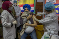 A hospital staff receives a COVID-19 vaccine at a government Hospital in Srinagar, Indian controlled Kashmir, Saturday, Jan. 16, 2021. India started inoculating health workers Saturday in what is likely the world's largest COVID-19 vaccination campaign, joining the ranks of wealthier nations where the effort is already well underway. (AP Photo/ Dar Yasin)