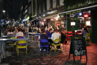 People eat and drink outside in Soho, in London, Tuesday, Sept. 22, 2020. Britain's Prime Minister, Boris Johnson, has announced that pubs and restaurants closing at 10pm, due to the spike of cases of coronavirus across the United Kingdom. (AP Photo/Alberto Pezzali)