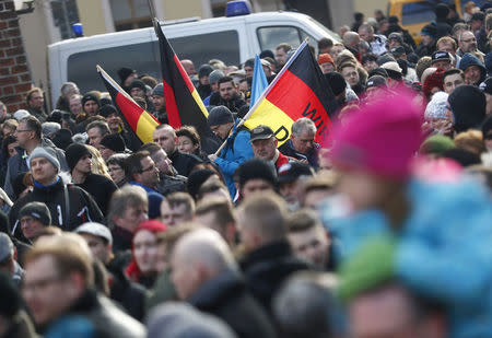 People hold German flags as they attend a demonstration against migrants in Cottbus, Germany February 3, 2018. REUTERS/Hannibal Hanschke