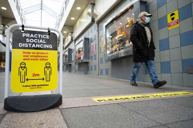 A man walks through a shopping arcade where social distancing measures are in force on October 28, 2020 in Bridgend, Wales. 