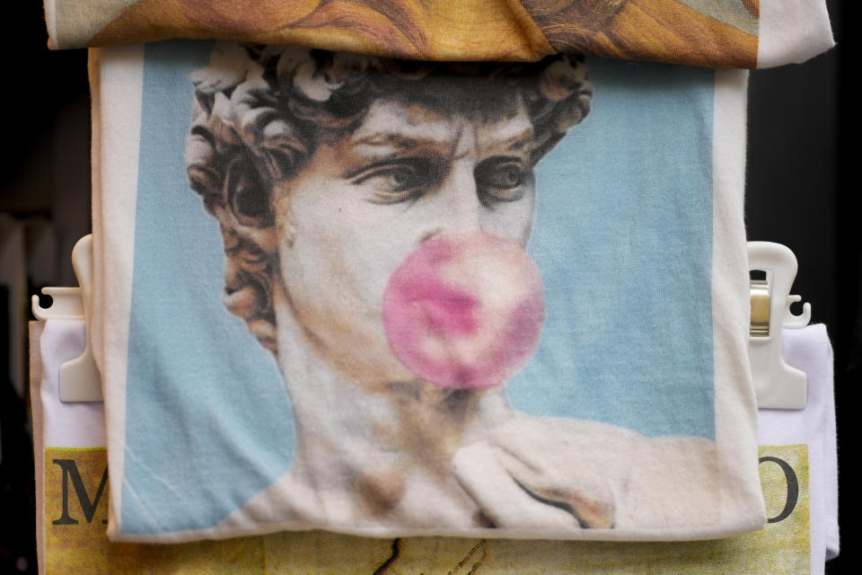 Una bolsa con un estampado de la estatua de David de Miguel Ángel del siglo XVI con una bomba de chicle a la venta, entre otros recuerdos, en una tienda en el centro de Florencia, centro de Italia, el lunes 18 de marzo de 2024. (Foto AP/Andrew Medichini)