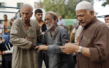 A wounded Palestinian man reacts after the death of his relatives, who medics said were killed during heavy Israeli shelling at the Shejaia district, at a hospital in Gaza City July 20, 2014. REUTERS/Suhaib Salem